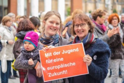 Zwei Frauen, eine davon mit Baby mit dem Schild: Mit der Jugend für eine euroäische Zukunft.